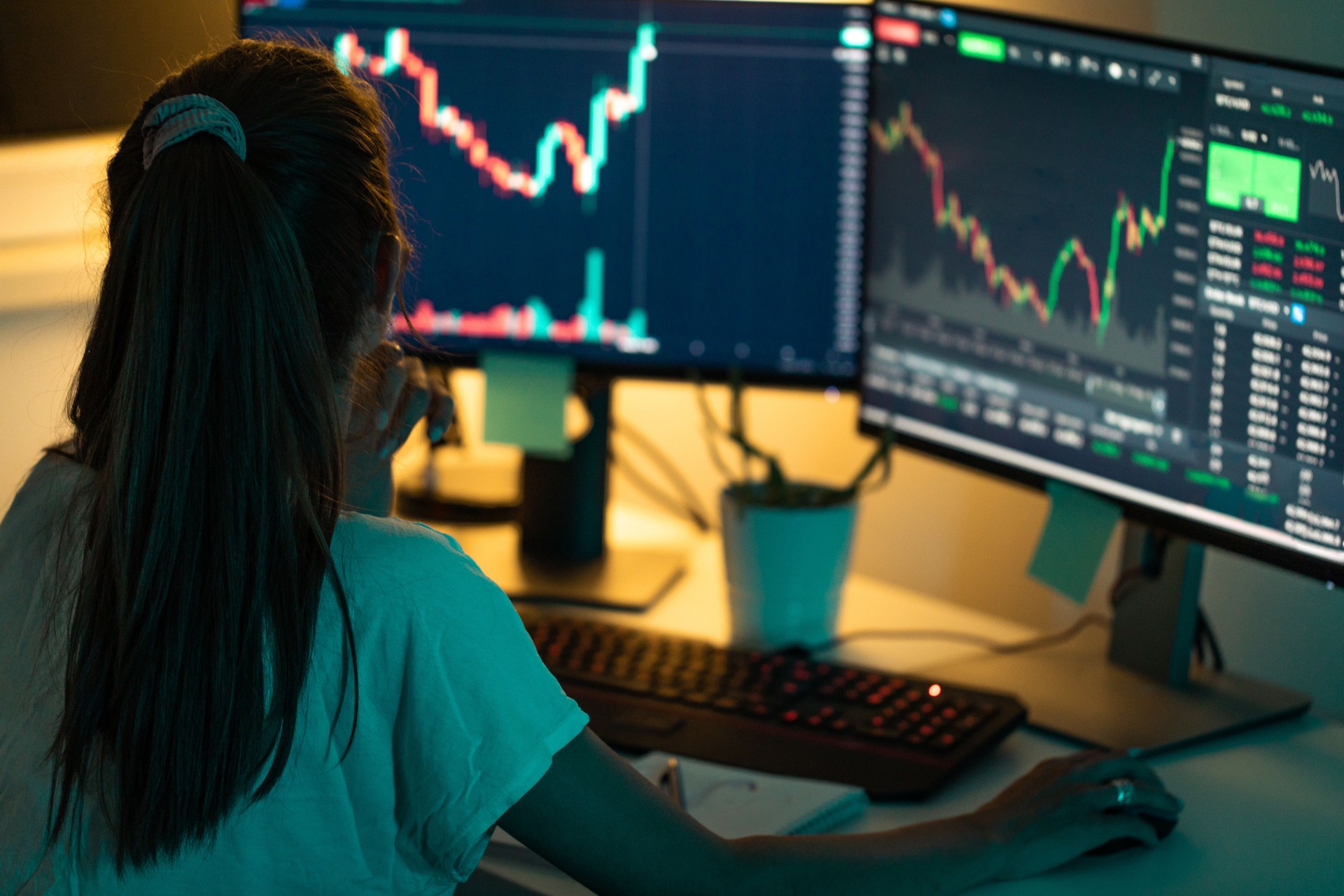 Young woman tracking and trading cryptocurrency using desktop computer